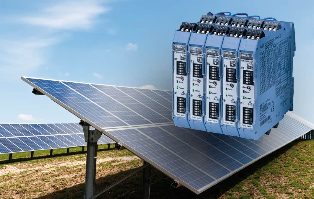 Knick-Messumformer über einem Photovoltaik-Panel in einem braunen Feld mit blauem, sonnigem Himmel im Hintergrund